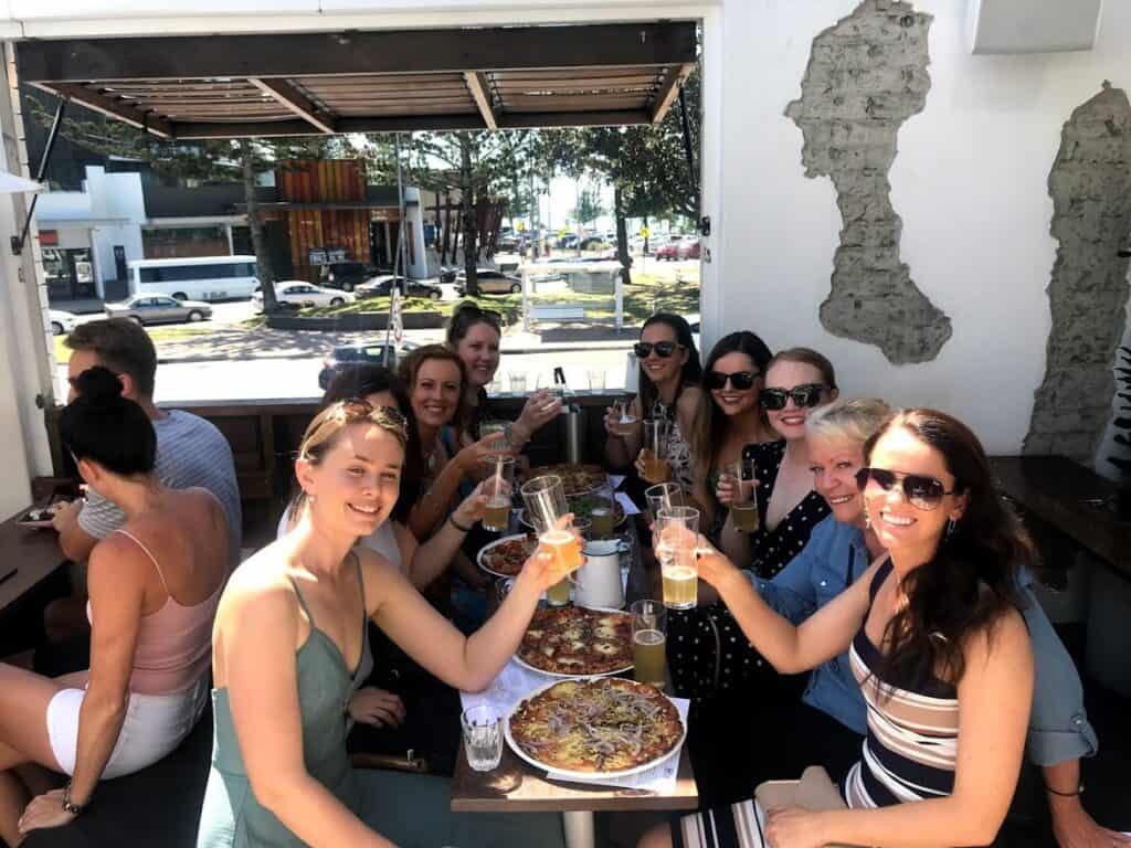ladies enjoying their beer and pizzas