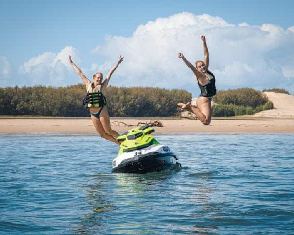 tow ladies is jumping from the jet ski