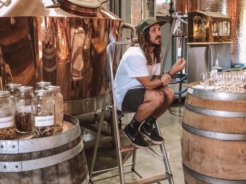 long haired man in white tee is sitting in the ladder